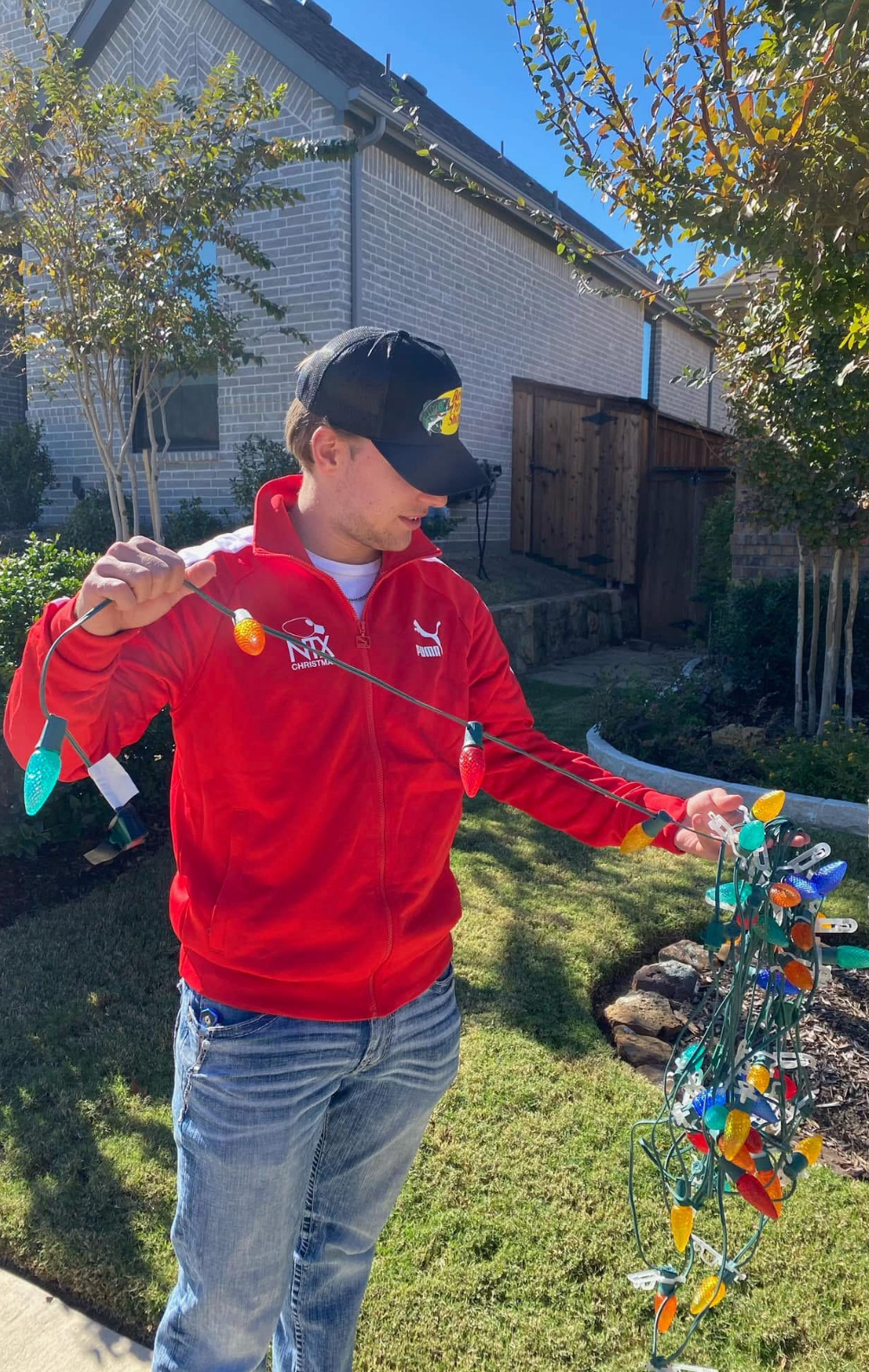 NTX Christmas crew member displaying colorful LED light strand