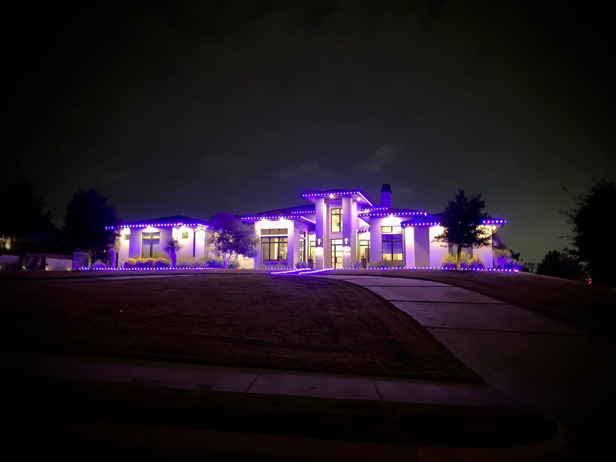 Modern purple LED lights outlining luxury home roofline